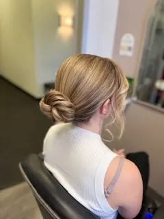 Sleek chignon with face framing tendrils