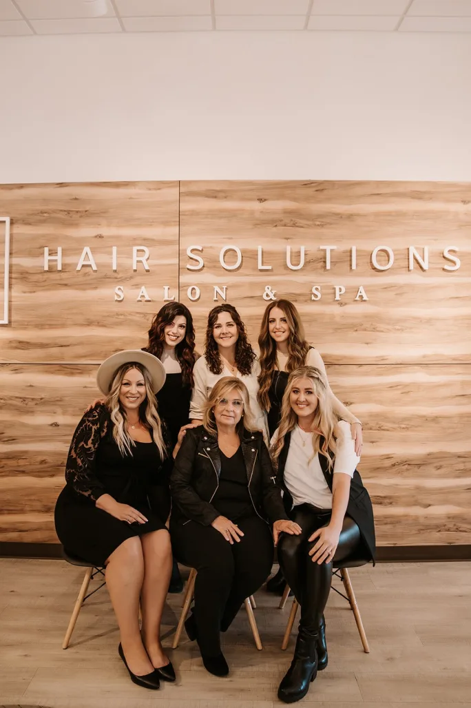 The co-owners of Hair Solutions Salon & Spa gather under their logo.
