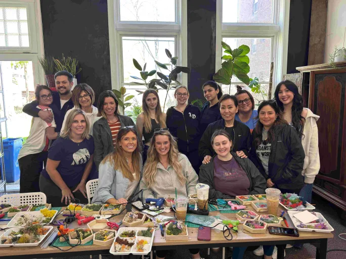 Seated behind a table full of craft materials, the team from Studio 6A Salon & Spa