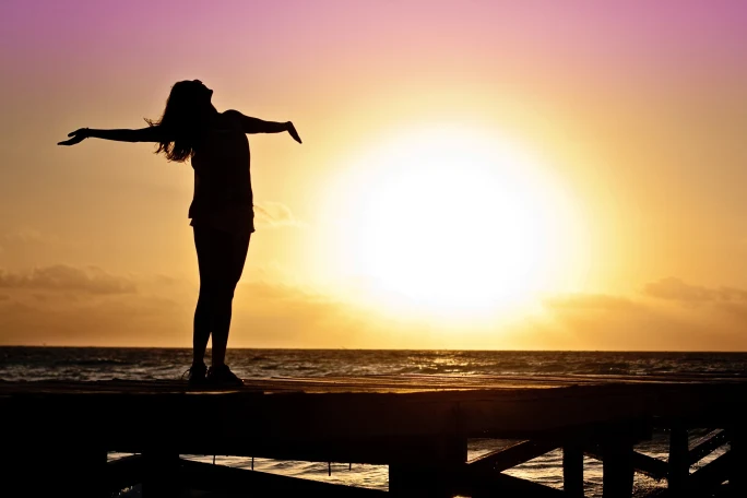 A woman greets the sunrise