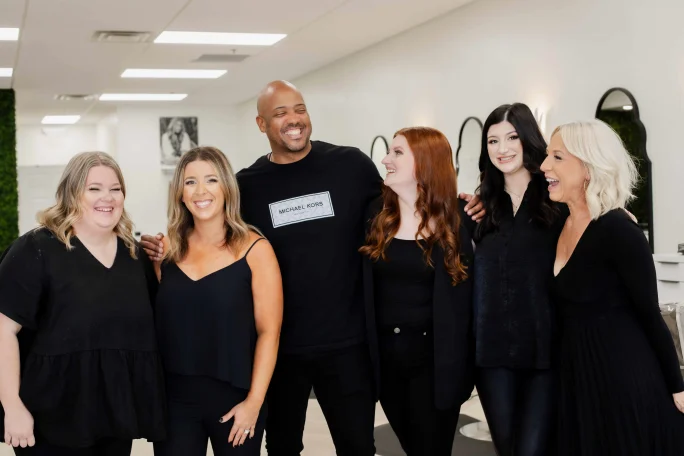 Standing and dressed in black the team from The Blonde Salon