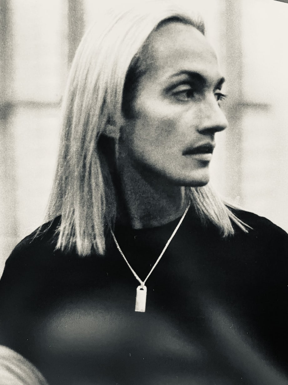 A man with long blonde hair in profile.