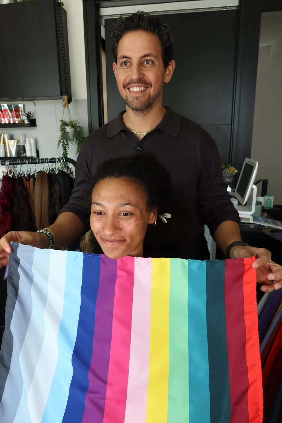 A man holds a piece of fabric in front of a woman's face
