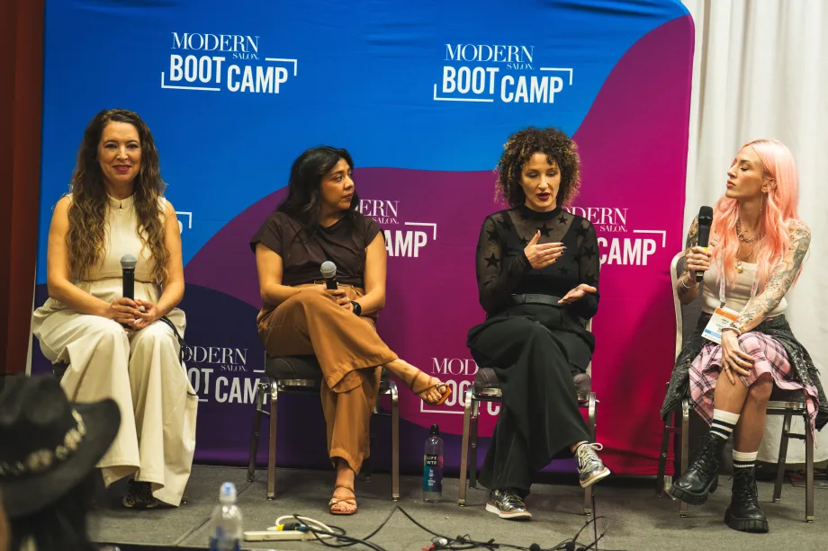 Four women on a stage with microphones.