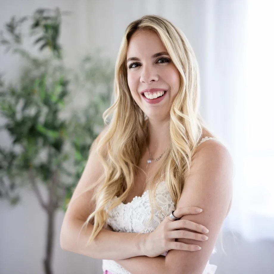 blonde woman smiling in a white tank top