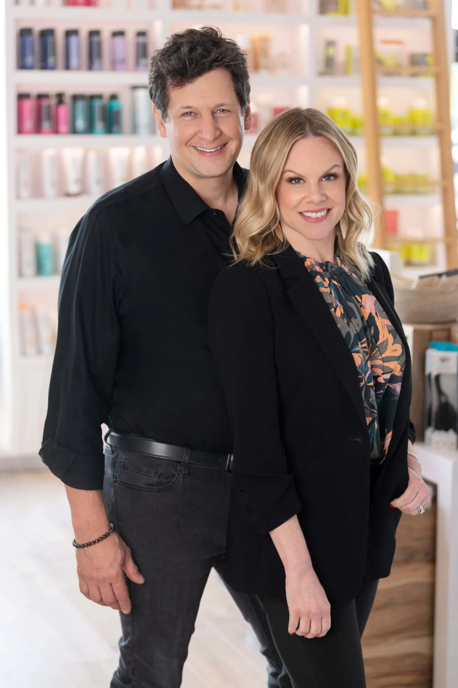 A couple proudly stand in their renovated salon.