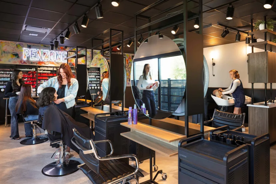 Multiple stations, a shampoo area and a color bar make up the training salon within BASE ONE in Columbus, Ohio.