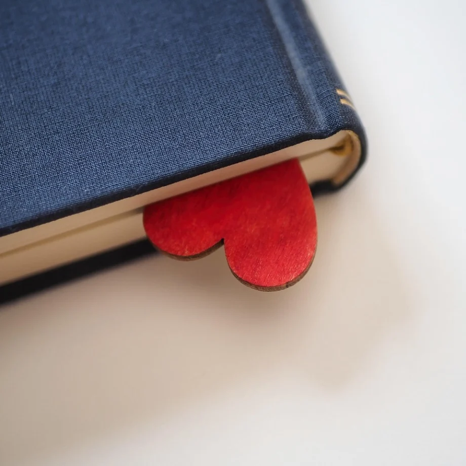 A book with a wooden heart tucked inside and peeking out