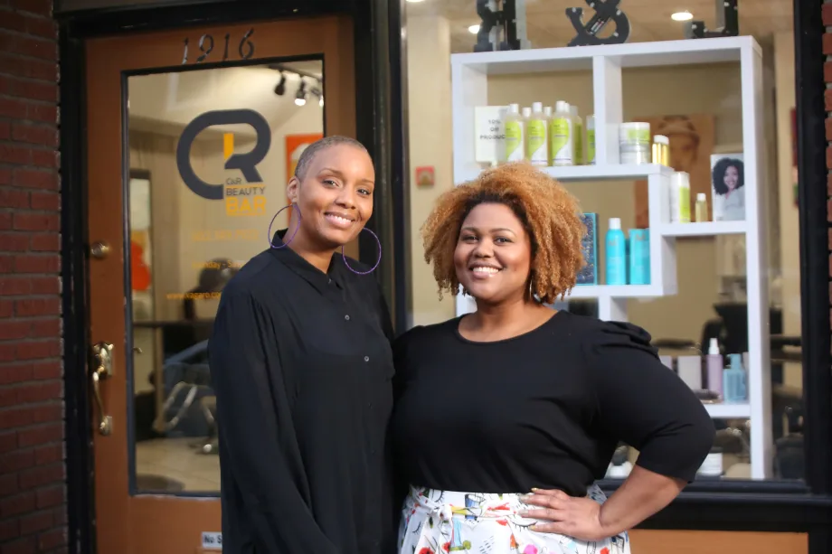 Owners Chenica Racine and Ricka O'Bannon outside the branded front door of their salon C&R Beauty Bar.