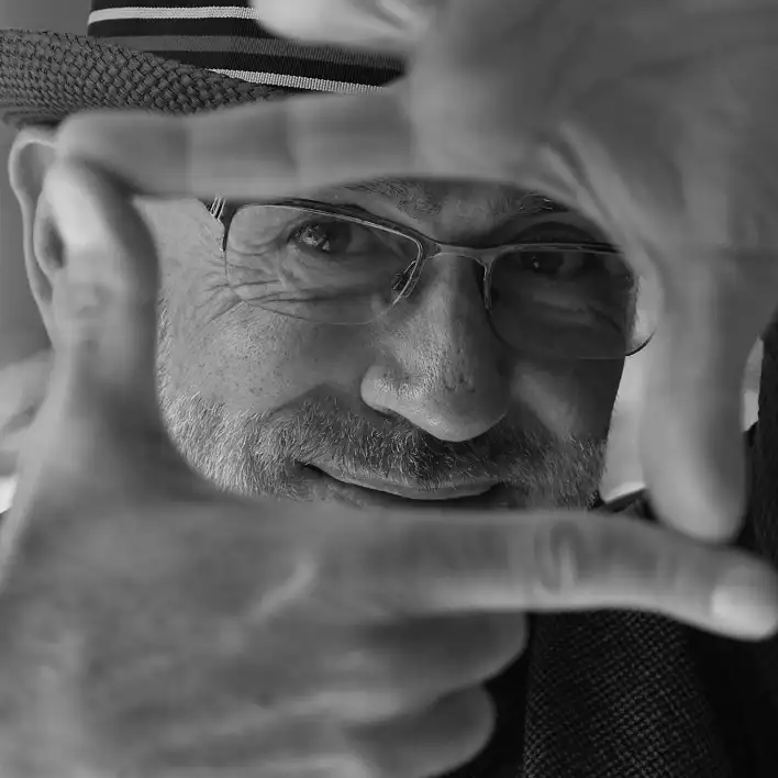 Daniel Cubillo, author of The Creative Masterind mind, peeks through his hands, resembling a television frame.
