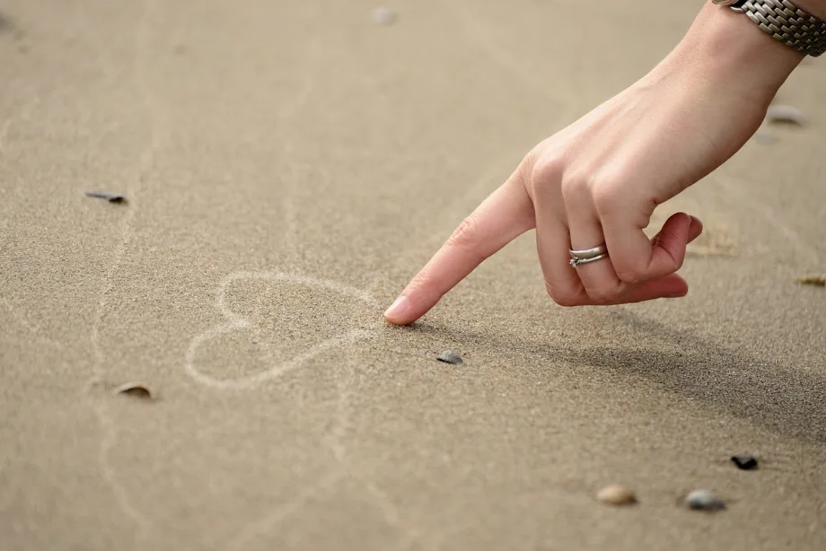 Drawing a heart in the sand.