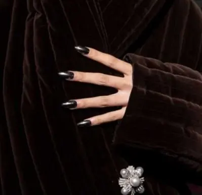 Dark, stiletto nails against a brown fur coat.