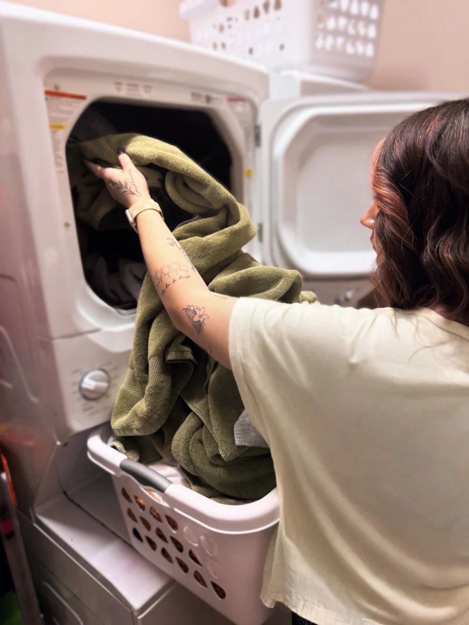 A stylist puts a load in the salon's washing machine.
