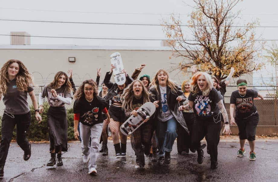 With skate boards in hand, a group of stylists playfully charge the photographer.