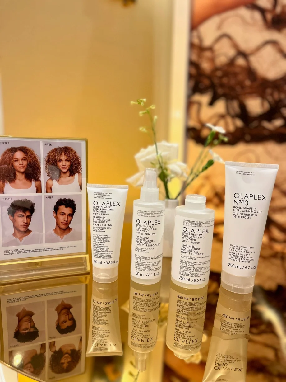 Several hair care products on a mirror.