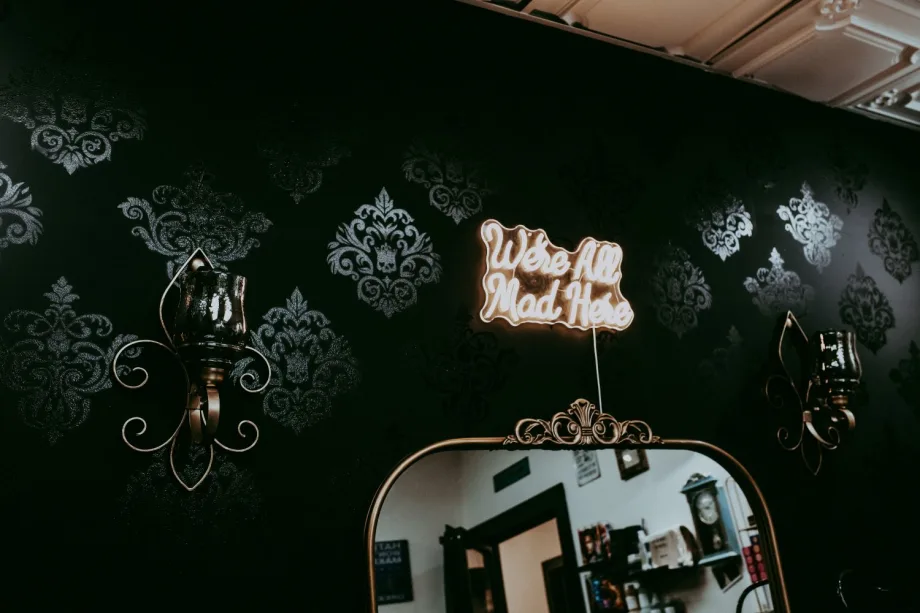 Against her damask, stenciled wall, pops out a line from "Alice in Wonderland"--"We're all mad here."