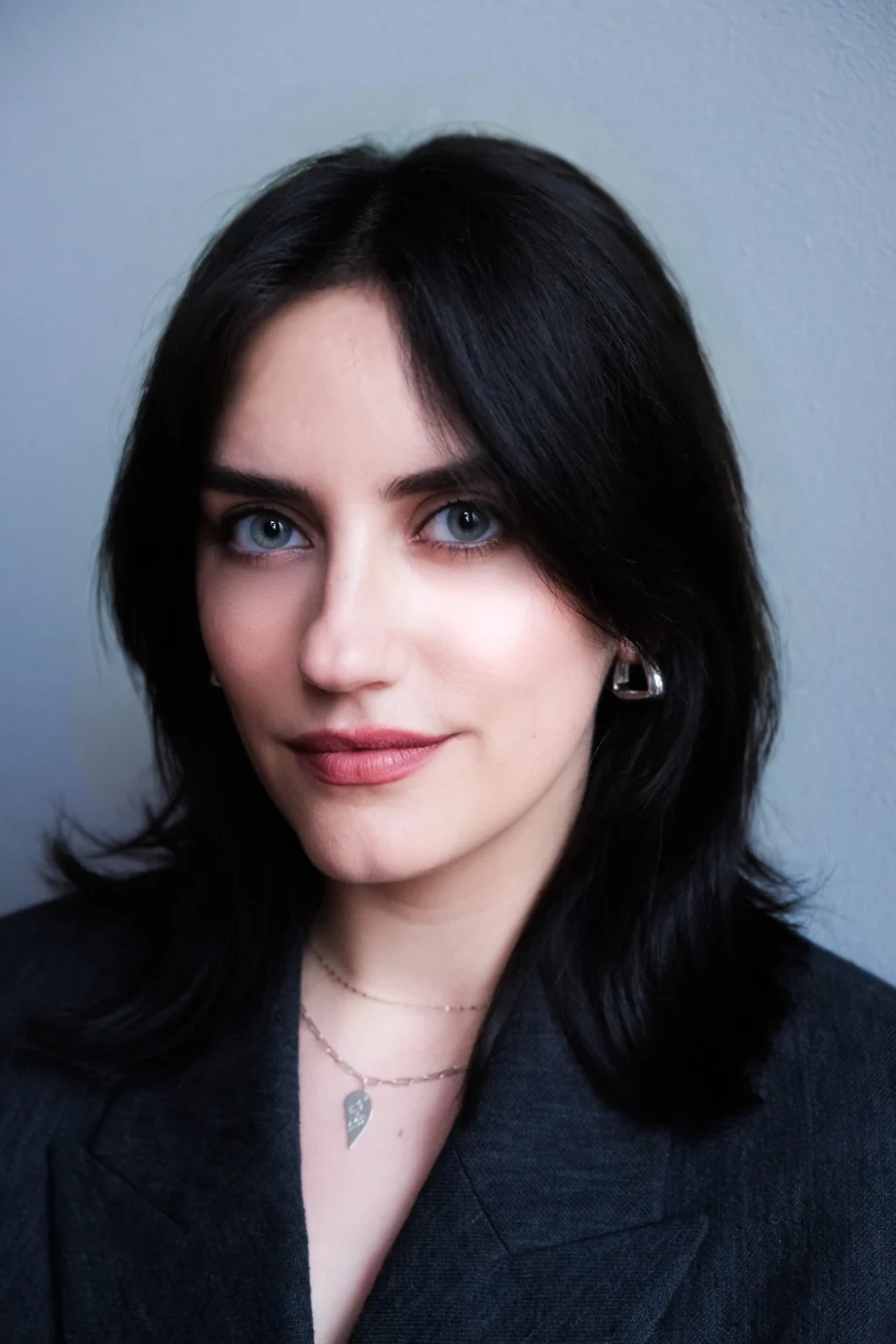 A woman in a suit jacket with dark hair