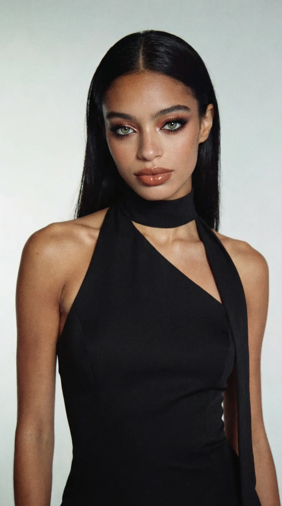 A model with very dark brunette hair in a black sleeveless top.