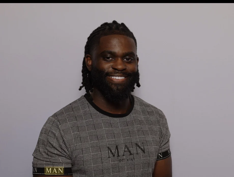 A man with dark hair and a beard, smiling.