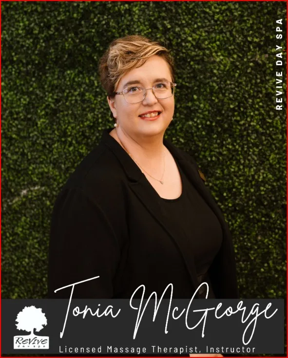 A photo of a woman in black against a green wall.