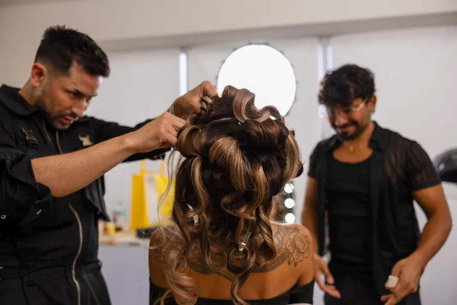 Two hairdressers collaborate on a model's hair on the Modern Salon and Ulta Beauty shoot.
