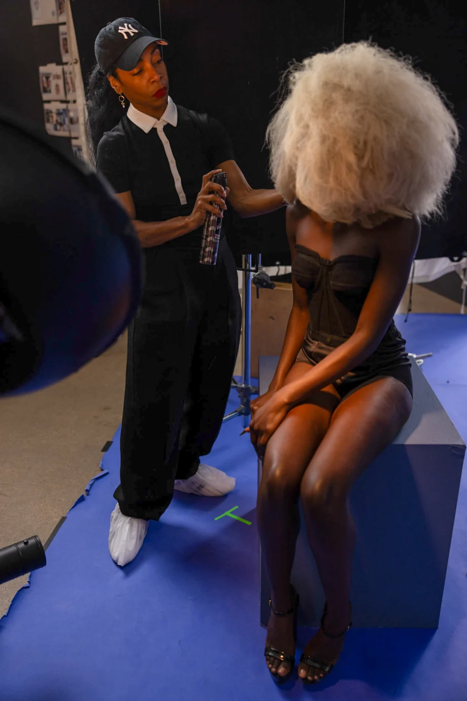 A stylist works on a model with a large blonde afro at the Modern Salon photo shoot.