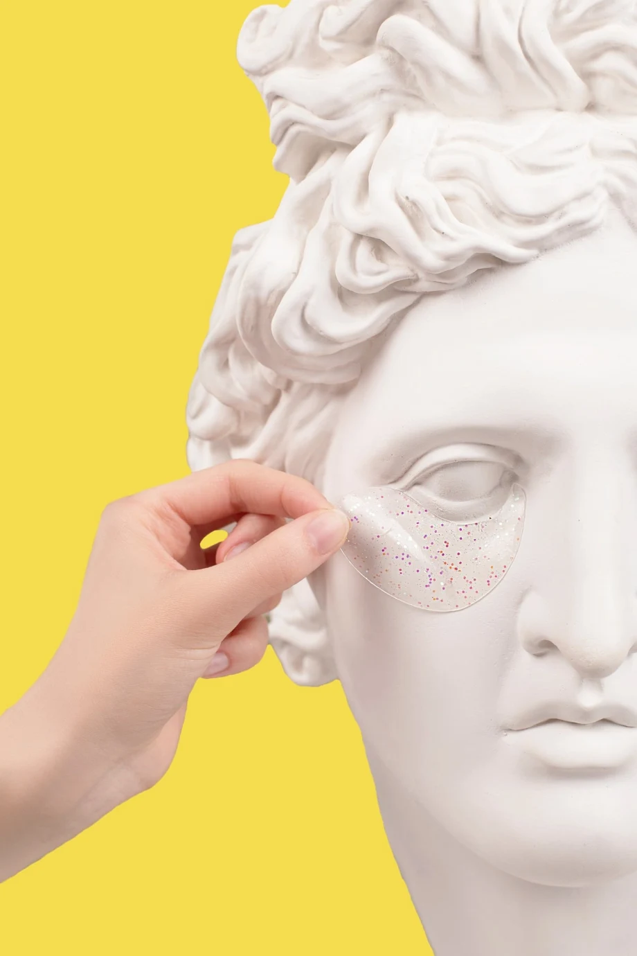A marble statue has eyelid mask applied